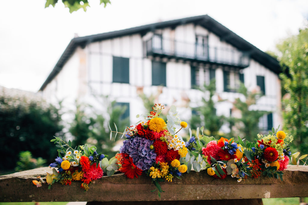 PLUSIEURS BOUQUETS POSES SUR UN REBORD EN PIERRE MAISON BASQUE