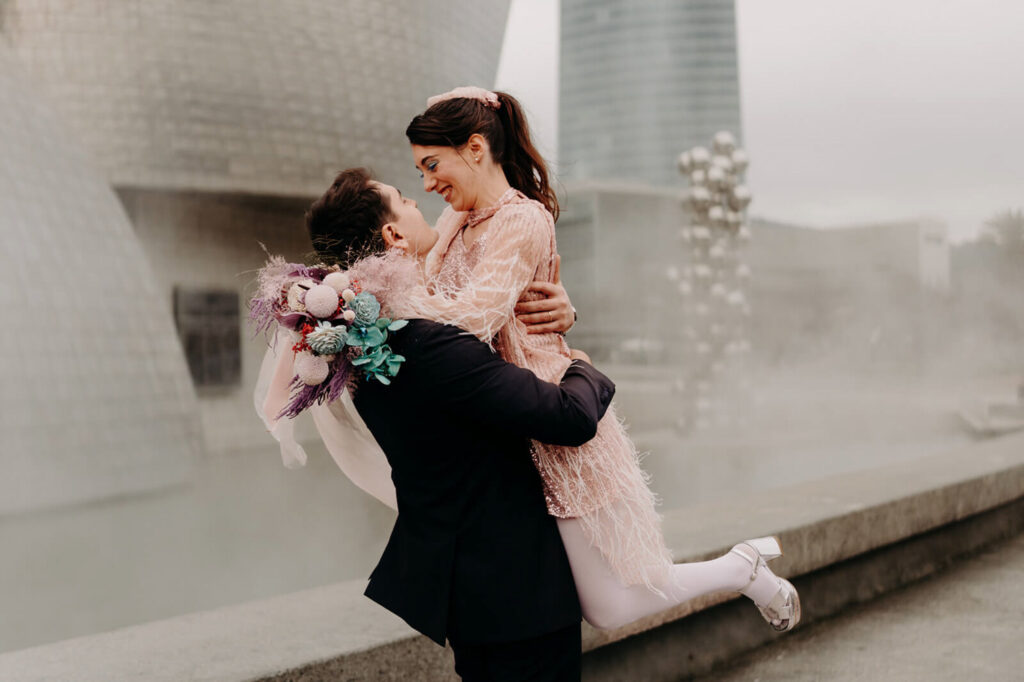 couple d'amoureux dans une ambiance brumeuse dans le parc du musée Guggenheim à Bilbao lors d'un shooting d'inspiration mariage avec une équipe de prestataire de spécialisé dans le mariage atypique, urbain et décalé